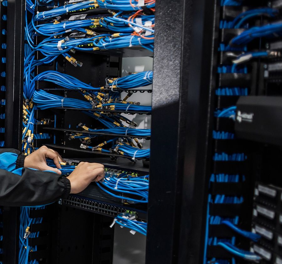 Técnico conectando cableado de red en un rack de comunicaciones